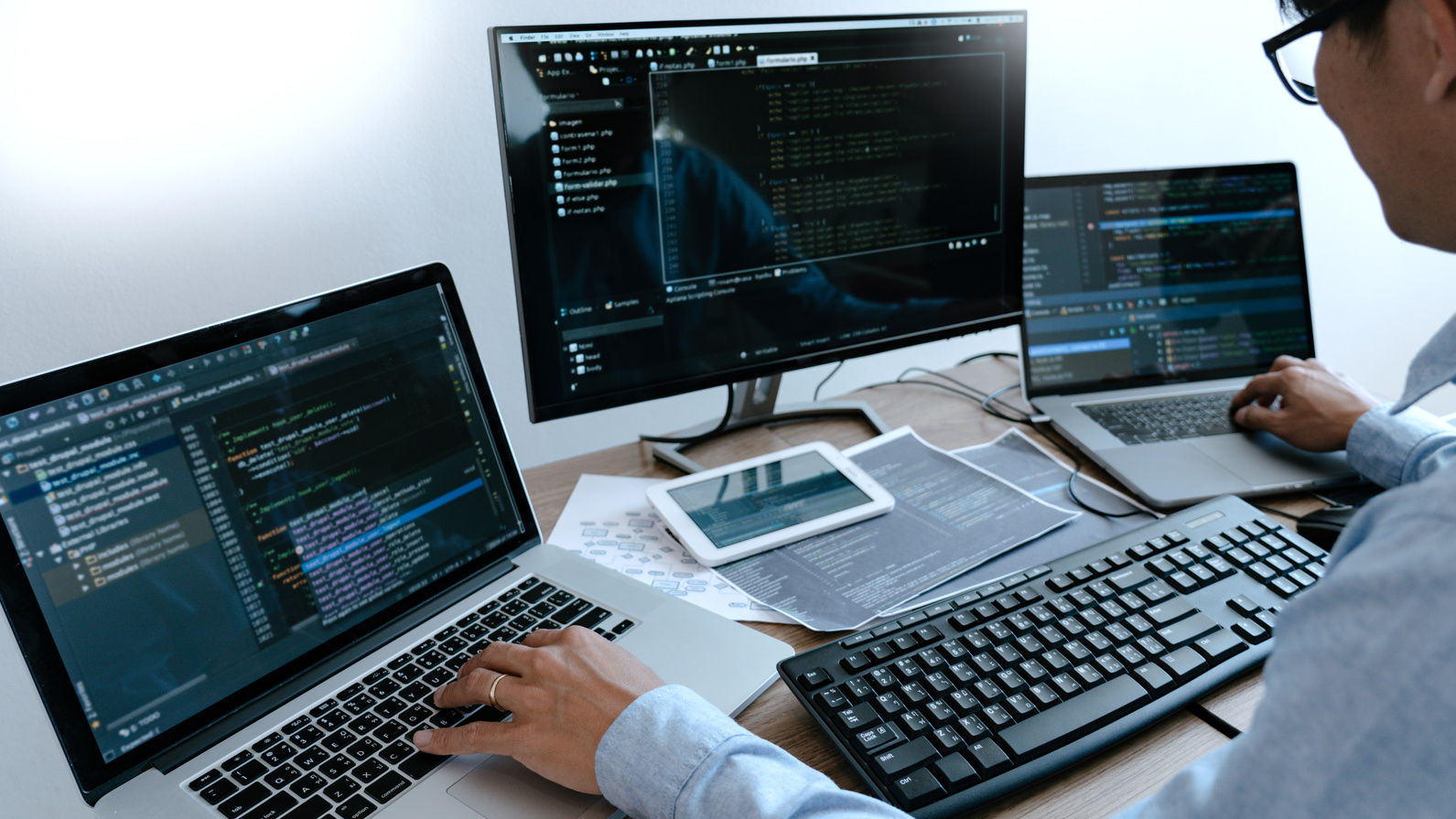 Programmer Typing Code on Desktop Computer